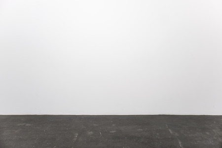 Minimalistic interior with an empty white wall and stone floorの写真素材