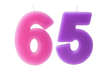 Colorful birthday candles in the form of the number 65 on white backgroundの写真素材