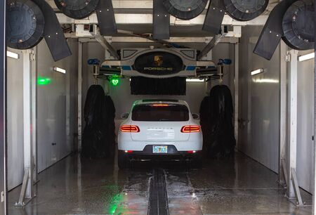 Miami, FL, USA - April 16, 2019: White car Porsche Macan on an automatic car wash. Special car wash Porsche only.のeditorial素材