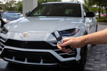Miami, FL, USA - April 16, 2019:Male Hand Unlocks Luxury White Lamborghini Urus. The Lamborghini Urus is an SUV manufactured by Italian car manufacturerのeditorial素材
