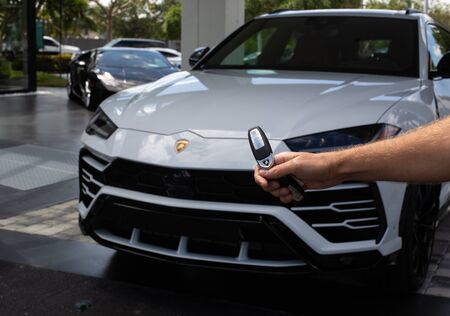 Miami, FL, USA - April 16, 2019:Male Hand Unlocks Luxury White Lamborghini Urus. The Lamborghini Urus is an SUV manufactured by Italian car manufacturerのeditorial素材