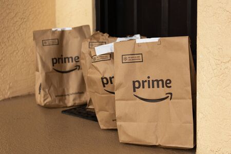 Miami, FL, USA - August 6, 2019: Image of  an Amazon Prime packages at apartment door.Amazon is an online company and is the largest retailer in the world.のeditorial素材