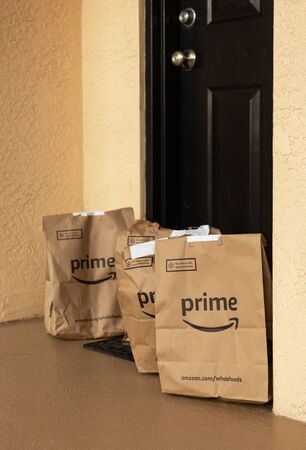 Miami, FL, USA - August 6, 2019:  Amazon Prime packages at apartment door. Amazon is an online company and is the largest retailer in the world.Amazon Prime is a service from Amazon which delivers parcels fast, in 1 dayのeditorial素材