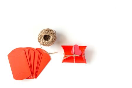 Image of Preparing for Christmas, New Year, packaging gifts: Red Packages and rope on a white background. Handmade gift on white background. Holiday Concept.の写真素材