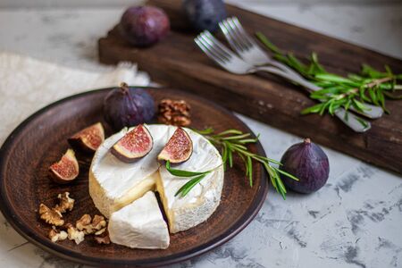 Ripe, beautiful, purple figs. Sweet and juicy. Mediterranean fruit is very healthy. On a plate is Brie cheese. On a light gray background copyspace there is an empty place. Food for vegetarians.の写真素材