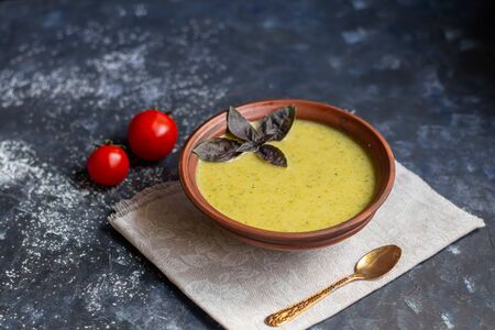 Detox green broccoli cream soup with chia seeds, red onions, green peppers, cherry tomatoes and croutons on a gray background. Healthy eating concept. Copy space.の写真素材