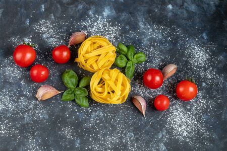 Ingredients for cooking Italian pasta. Pasta, basil, cheese, cherry tomatoes, olive oil, egg, yolk. On a light background. Copy space.の写真素材