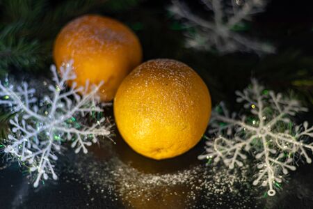 Tangerines on a black background. Christmas tree branch. New Year. Copy space. Vegetarianismの写真素材