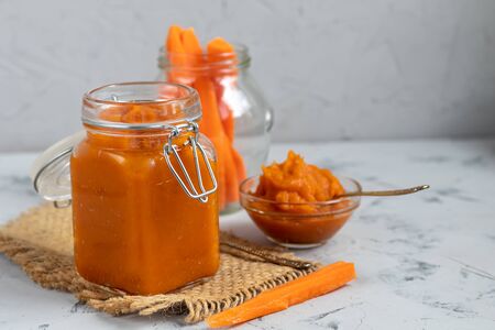 Carrot jam with orange juice, decorated with mint and slices of lemon on a pineapple, stone background. Autumn product. The horizontal location. Copy space. Flat lay.の写真素材