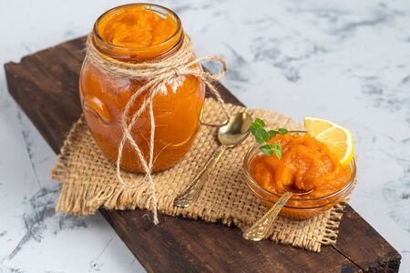 Carrot jam with orange juice, decorated with mint and slices of lemon on a pineapple, stone background. Autumn product. The horizontal location. Copy space.の写真素材