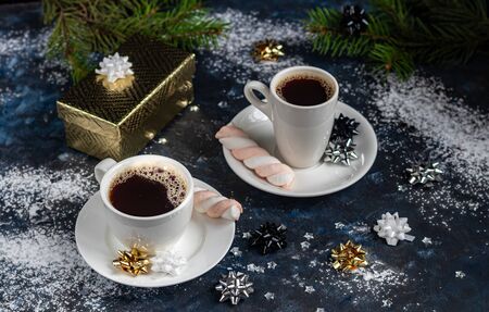 A cup of hot coffee. Good New Year spirit. White snowflakes and Christmas decorations. On a black background. Copy space.のeditorial素材