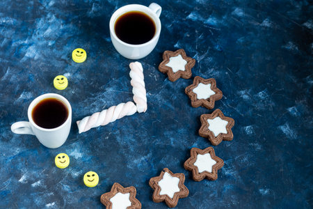 A cup of hot coffee. Good New Year spirit. White snowflakes and Christmas decorations. On a black...