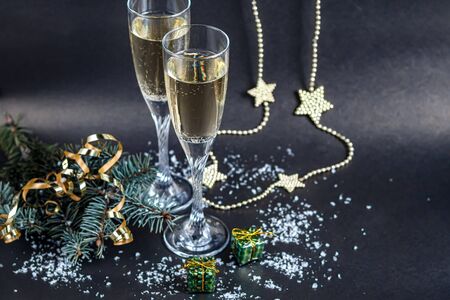 Christmas mood. Glasses with champagne. New Year. Christmas-tree decorations, coniferous branches. Copy space.の写真素材