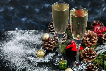 Christmas mood. Glasses with champagne. New Year. Christmas-tree decorations, coniferous branches. Copy space.の写真素材