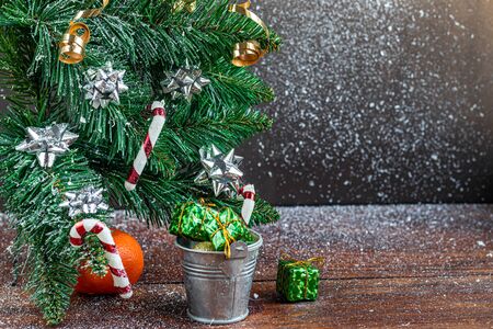Christmas presents near a snowy branch. New Year. Festive mood, New Year's toys. Brown background. Postcard. Banner Copy space.の写真素材