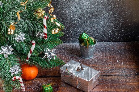 Christmas presents near a snowy branch. New Year. Festive mood, New Year's toys. Brown background. Postcard. Banner Copy space.の写真素材