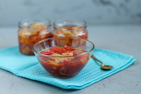 In glass jars Lecho salad of canned bell pepper and tomato. Harvesting for the winter. Vegetarian dish. Copy space.の写真素材
