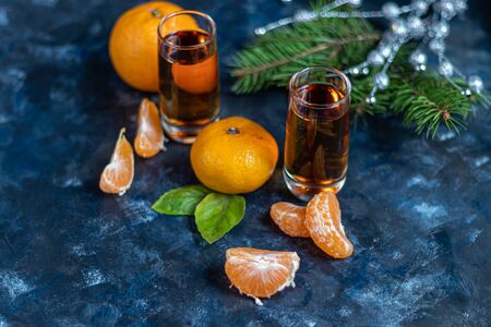 Cognac in glasses on a dark background. Near tangerines. Festive mood. Copy space.の写真素材