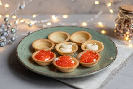 Tartlets with soft cheese, shrimp and red caviar. Holiday dish. On a green plate. Copy space.の写真素材