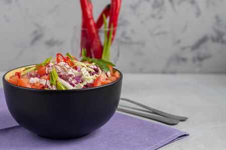 Diet salad made from fresh vegetables. Peking cabbage lilac and green, tomatoes, green onions and chili peppers. Dressed with olive oil. On a light gray background. Copy space.の写真素材