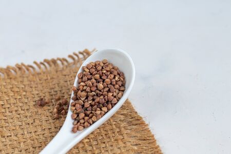 Buckwheat raw, medium rare. Measured for making porridge. On a gray background under concrete.の写真素材