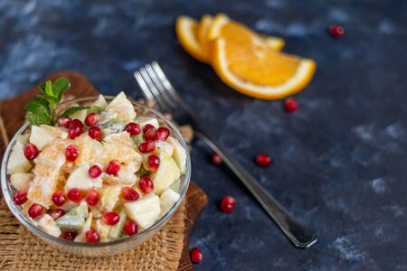 Diet fruit salad for breakfast. Kiwi orange banana and apple diced and seasoned with yogurt with honey. Healthy food, vegetarianism. On a dark background. Copy space.の写真素材