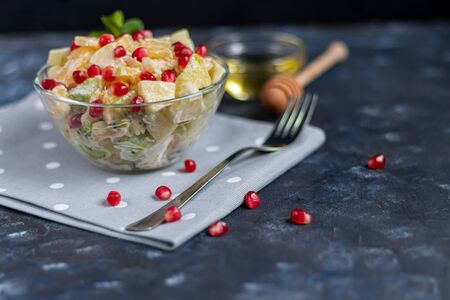 Diet fruit salad for breakfast. Kiwi orange banana and apple diced and seasoned with yogurt with honey. Healthy food, vegetarianism. On a dark background. Copy space.の写真素材