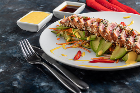 Japanese food. Tataki with tuna. Fried fish with sesame seeds and soy sauce, wasabi, lime. On a...
