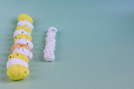 Easter, colored eggs on a light background, holiday background for your decoration. Near willow branches, feathers. Copy spaceの写真素材