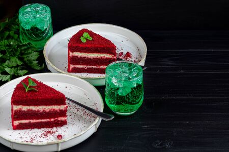 Cake Red velvet on two white plates, two servings. On a black background. Birthday, holidays, sweets. Copy spaceの写真素材
