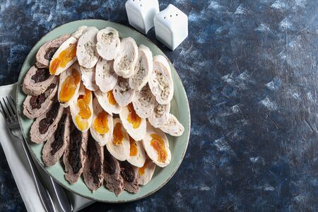 Chicken rolls with dried apricots, prunes and mushrooms. Sliced. On a dark background. Copy spaceの写真素材