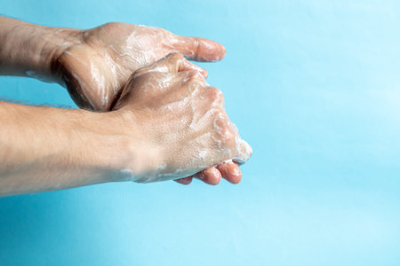 A man washes his hands with soap