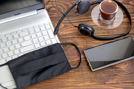 Coronavirus. Quarantine. Online training, education and freelance work. Laptop, phone and medical mask for protection. Coronavirus pandemic in the world. Closing offices.の写真素材