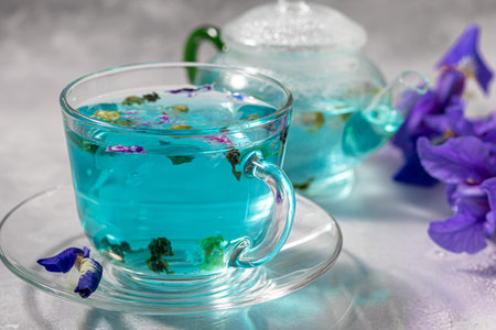 A cup of hot, blue tea with pea flowers. Blue peas. For healthy drinking, detoxifying the body. Gray background. Copy spaceの写真素材