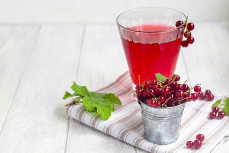 Red currants on a light wooden background. Vitamin cocktail. Copy space.の写真素材