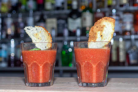 Gazpacho tomato soup. Cool summer lunch. In a glass decorated with croutons. At the bar in the restaurant. Foreground.の写真素材