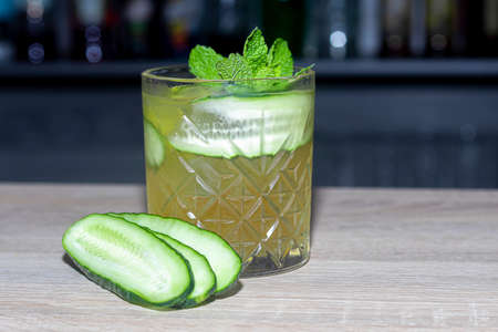 Refreshing summer strong cocktails with a slice of lime. Alcoholic drink. Garnished with a sprig of mint, citrus and ice cubes. In the bar. Foreground.の写真素材
