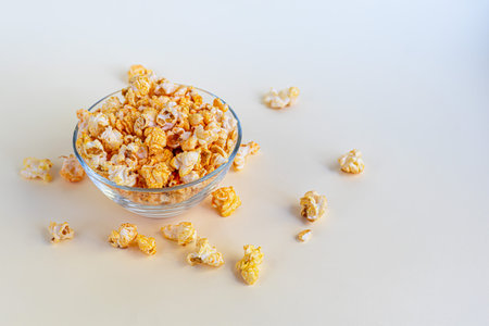 A transparent bowl of popcorn on a light surface. Copy space.の写真素材