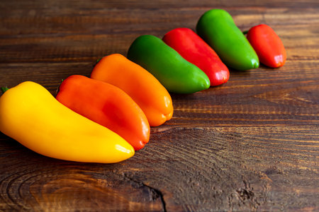 Bulgarian multicolored peppers on a wooden board. Healthy food, vitamins. Copy space.