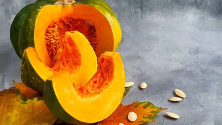 Fresh pumpkin on a gray background with pumpkin seeds. Autumn lunch concept. On a wooden background. Healthy dietary product. Copy space.の写真素材