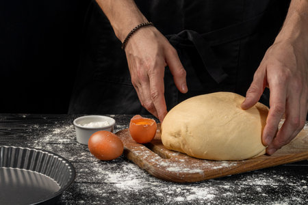 Making homemade bread. Step-by-step instruction. The cook shapes the dough. Wooden background. Copy...