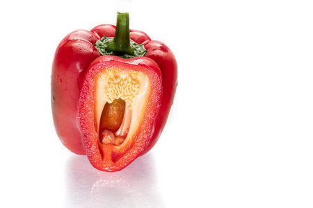 Red bell pepper in a cut on a white background. Isolate. Foreground.