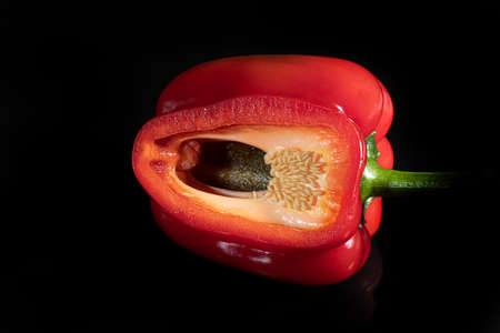 Red bell pepper in a cut on a black background. Isolate. Foreground.の写真素材