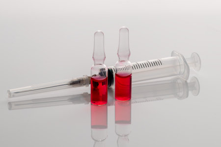 Ampoules with a medicine and a syringe on a light background.  vaccine. Medical concept. Isolate....