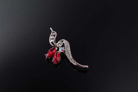 Bijouterie and jewelry on a dark background. Brooches and hairpins earrings and pendants. Copy spaceの写真素材