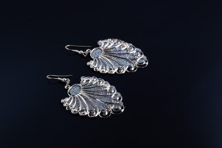 Bijouterie and jewelry on a dark background. Brooches and hairpins earrings and pendants. Copy space