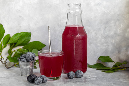 Plum compote in a glass. In the background there are plums. Tkemali sauce. Getting ready for winter....