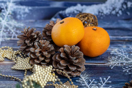 Tangerines on a gray background with branches of a Christmas tree, in the background a window with snow. New year concept.の写真素材