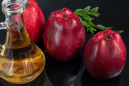Apple cider vinegar and red apples on a dark, wooden background. Selective focus. fermented product....