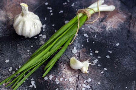 Green onions for salad or fritata. Spring harvest benefits and vitamins. On a dark background. copyspace.の写真素材